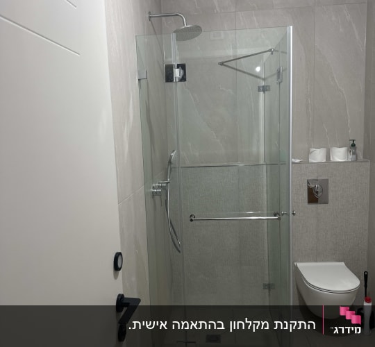 מקלחון פינתי מזכוכית שקופה עם פרזול נירוסטה בחדר רחצה מעוצב